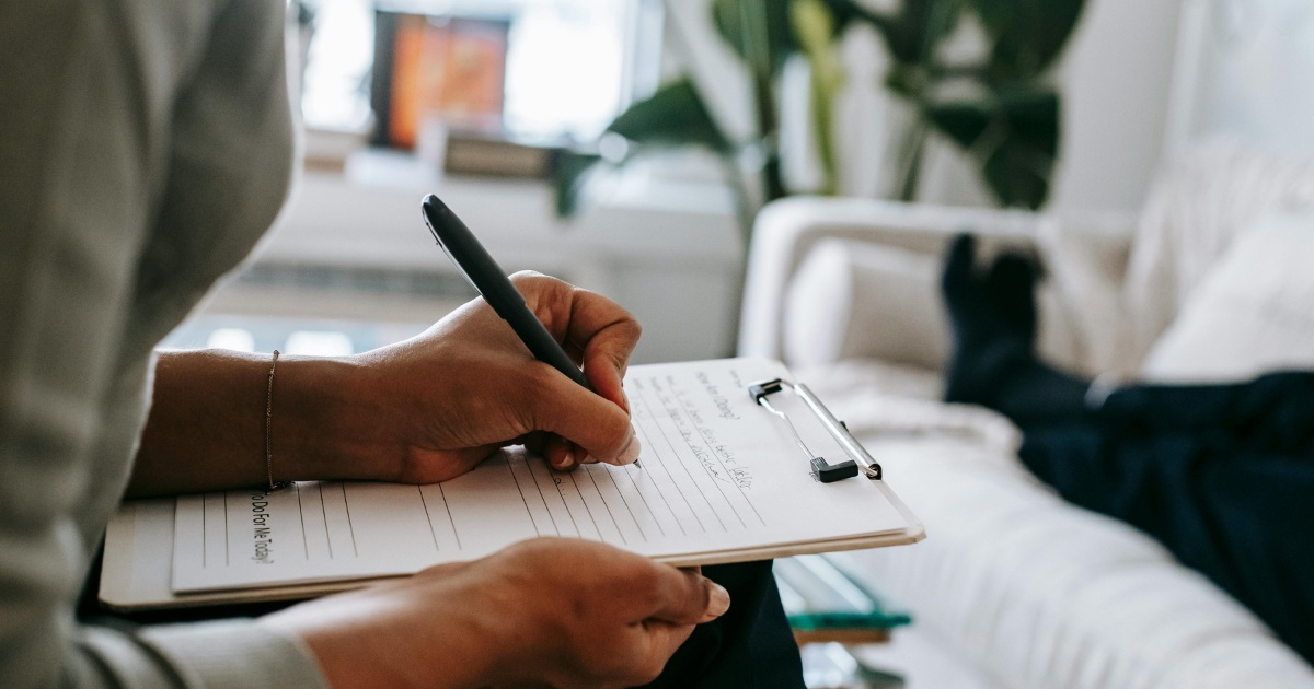 Homme assis écrivant avec un stylo plume sur un bloc-notes — conseils et réflexions destinés aux collectionneurs passionnés d’objets rares et authentiques.