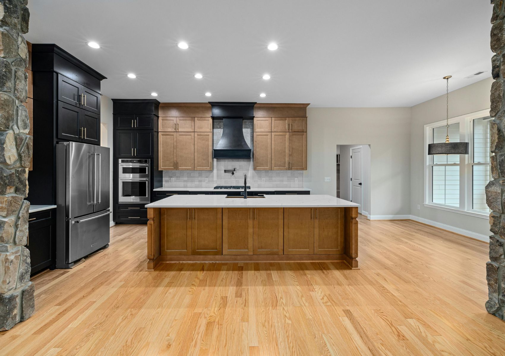 A large kitchen with wood floors and granite counter tops
