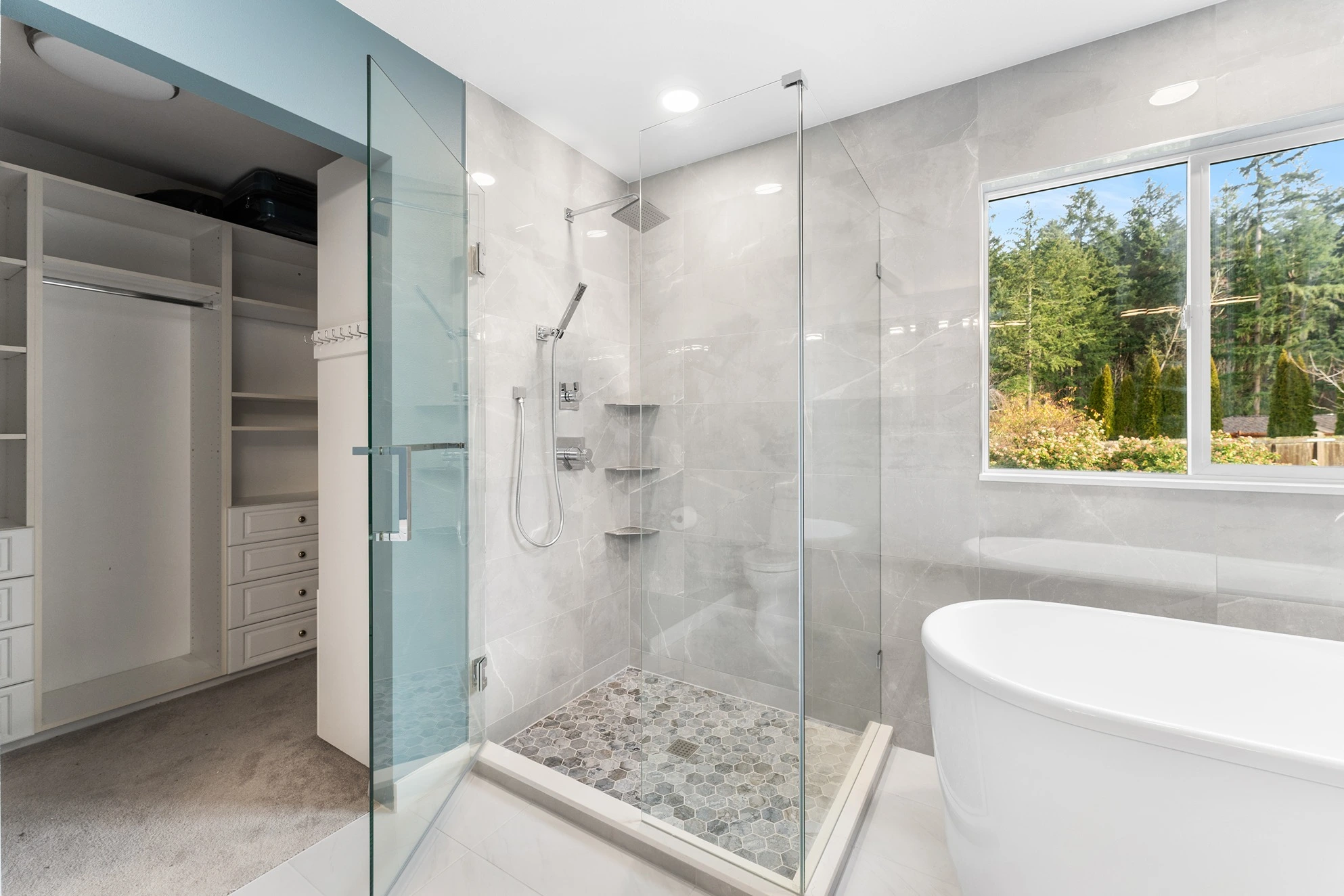 Completed primary bathroom remodel with a freestanding soaking tub and glass shower built to local King County permit standards.
