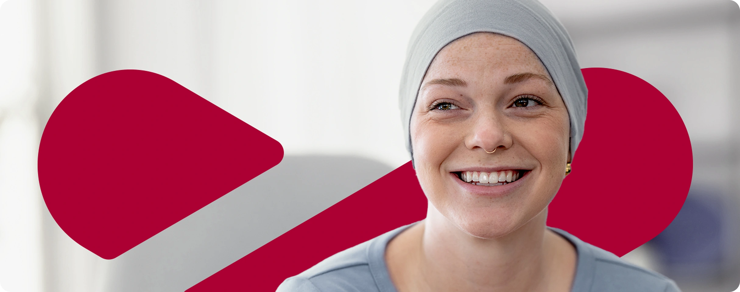 A woman with a headscarf smiles for the camera.