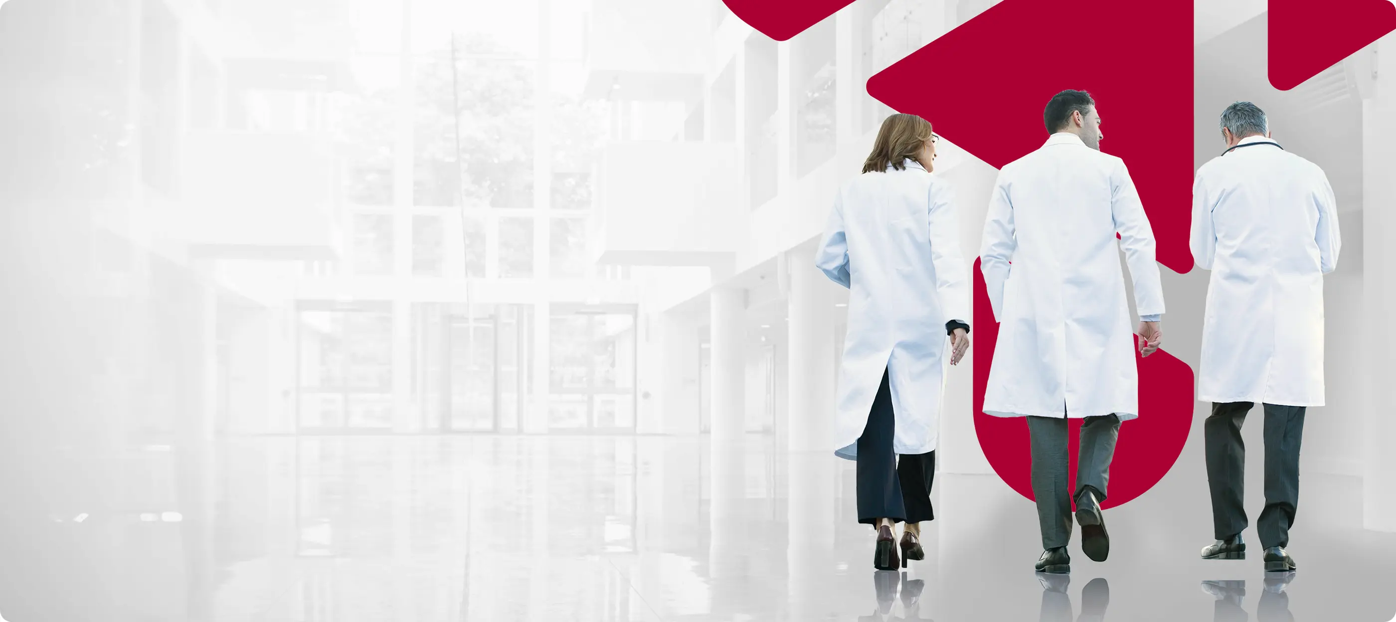 A group of people in lab coats walking down a hallway.