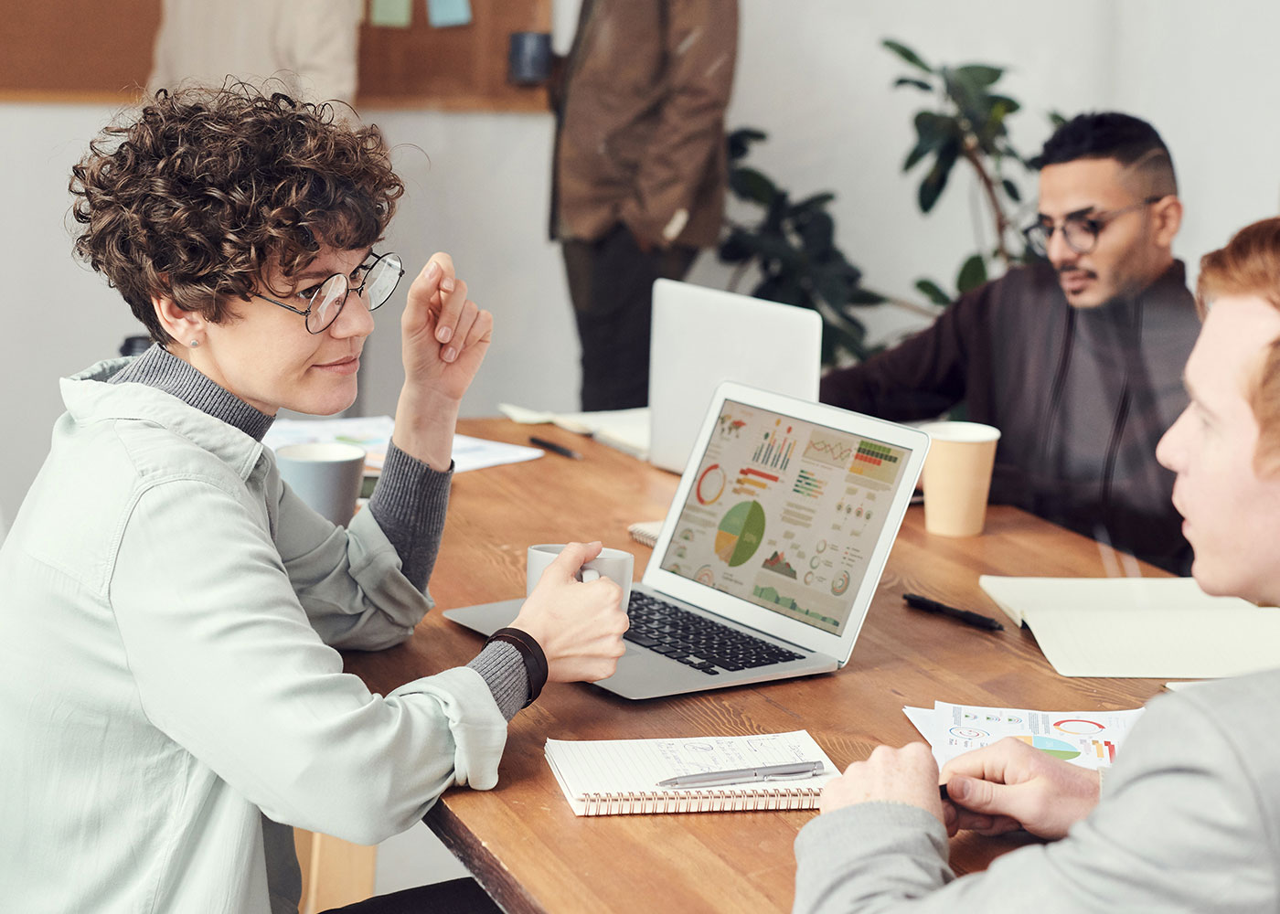 Asset finance concept - A professional woman using her smartphone near a well-organised bookshelf.