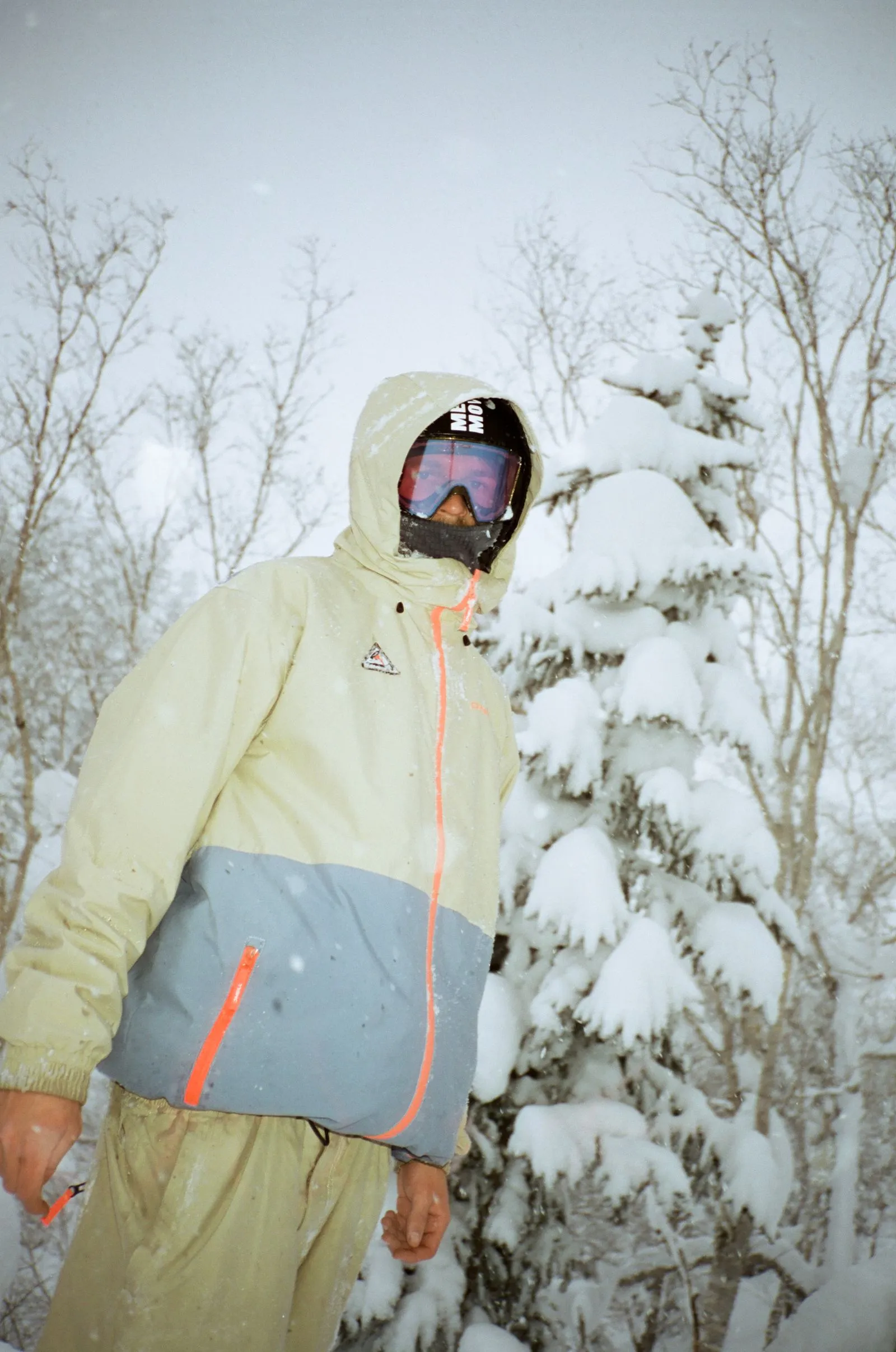 Person in winter jacket and ski goggles standing in snowy forest with snow-covered trees. Foto/Video von Felix Weise, Medienproduktion für Sport, Outdoor & Events im Allgäu, Kempten und Bayern.