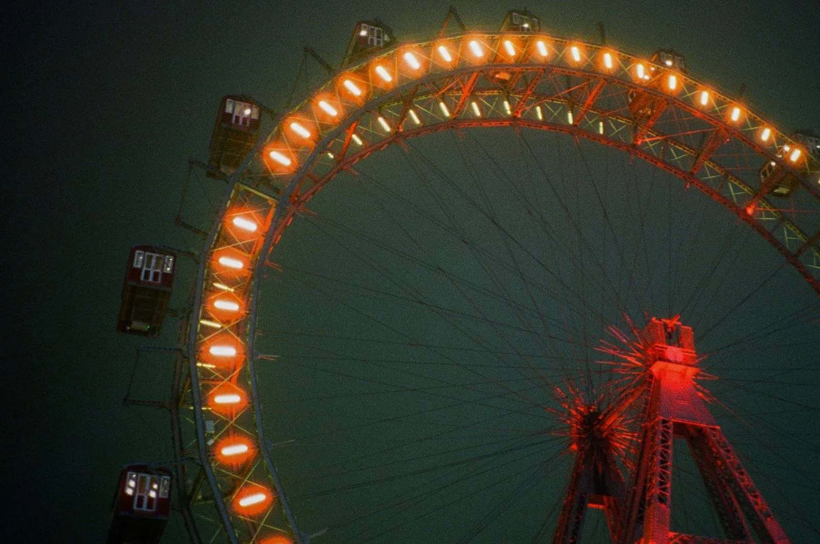 Beleuchtetes Riesenrad bei Nacht mit roten Kabinen und orangefarbenen Lichtern.
Foto/Video von Felix Weise, Medienproduktion für Sport, Outdoor & Events im Allgäu, Kempten und Bayern.