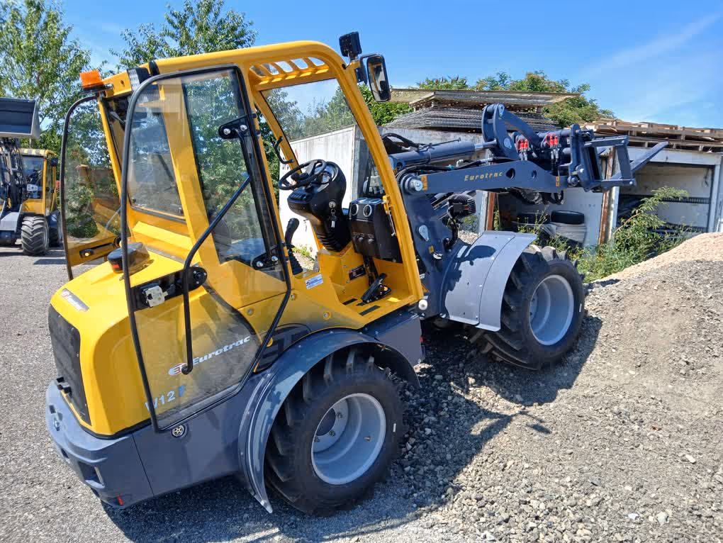 Eurotrac Baumaschine von Sadema GmbH im Einsatz, moderner Hoflader oder Minibagger mit Schaufel und Hydraulik, gelbes robustes Fahrzeug auf Baustelle oder Hof, kompakte Bauweise, starke Leistung und zuverlässige Technik für Landwirtschaft und Bau.
