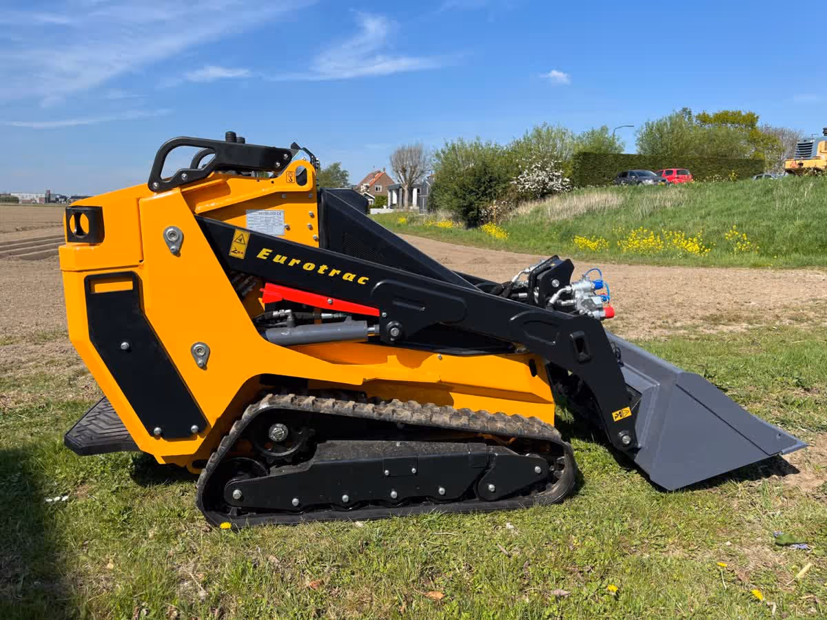 Eurotrac Baumaschine von Sadema GmbH im Einsatz, moderner Hoflader oder Minibagger mit Schaufel und Hydraulik, gelbes robustes Fahrzeug auf Baustelle oder Hof, kompakte Bauweise, starke Leistung und zuverlässige Technik für Landwirtschaft und Bau.