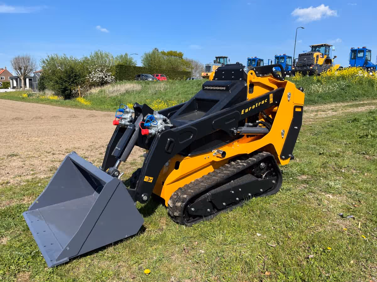 Eurotrac Baumaschine von Sadema GmbH im Einsatz, moderner Hoflader oder Minibagger mit Schaufel und Hydraulik, gelbes robustes Fahrzeug auf Baustelle oder Hof, kompakte Bauweise, starke Leistung und zuverlässige Technik für Landwirtschaft und Bau.