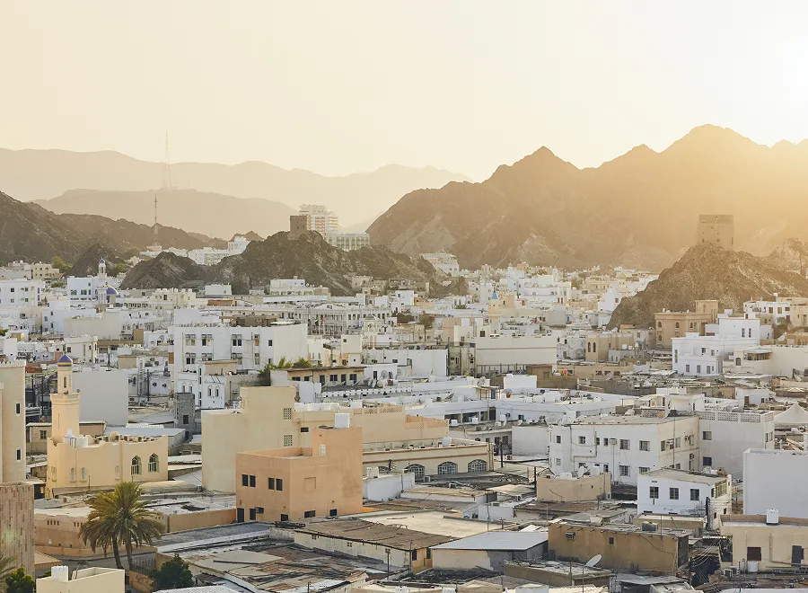 A city in Oman with mountains in the background