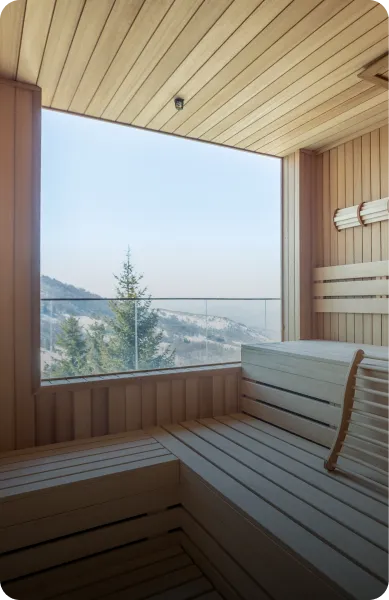 The interior of the sauna with a view of the mountainside outside the window