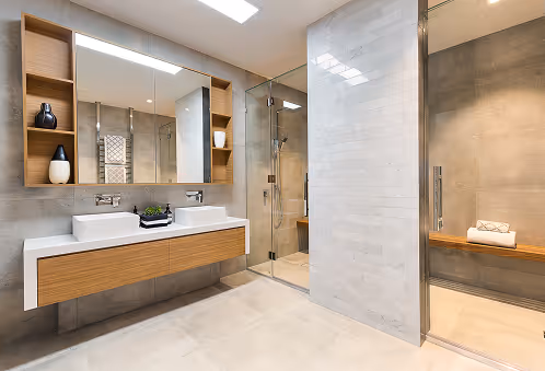 Modernes Badezimmer mit Doppelwaschbecken, großem Spiegel und Duschkabine mit Glaswand.