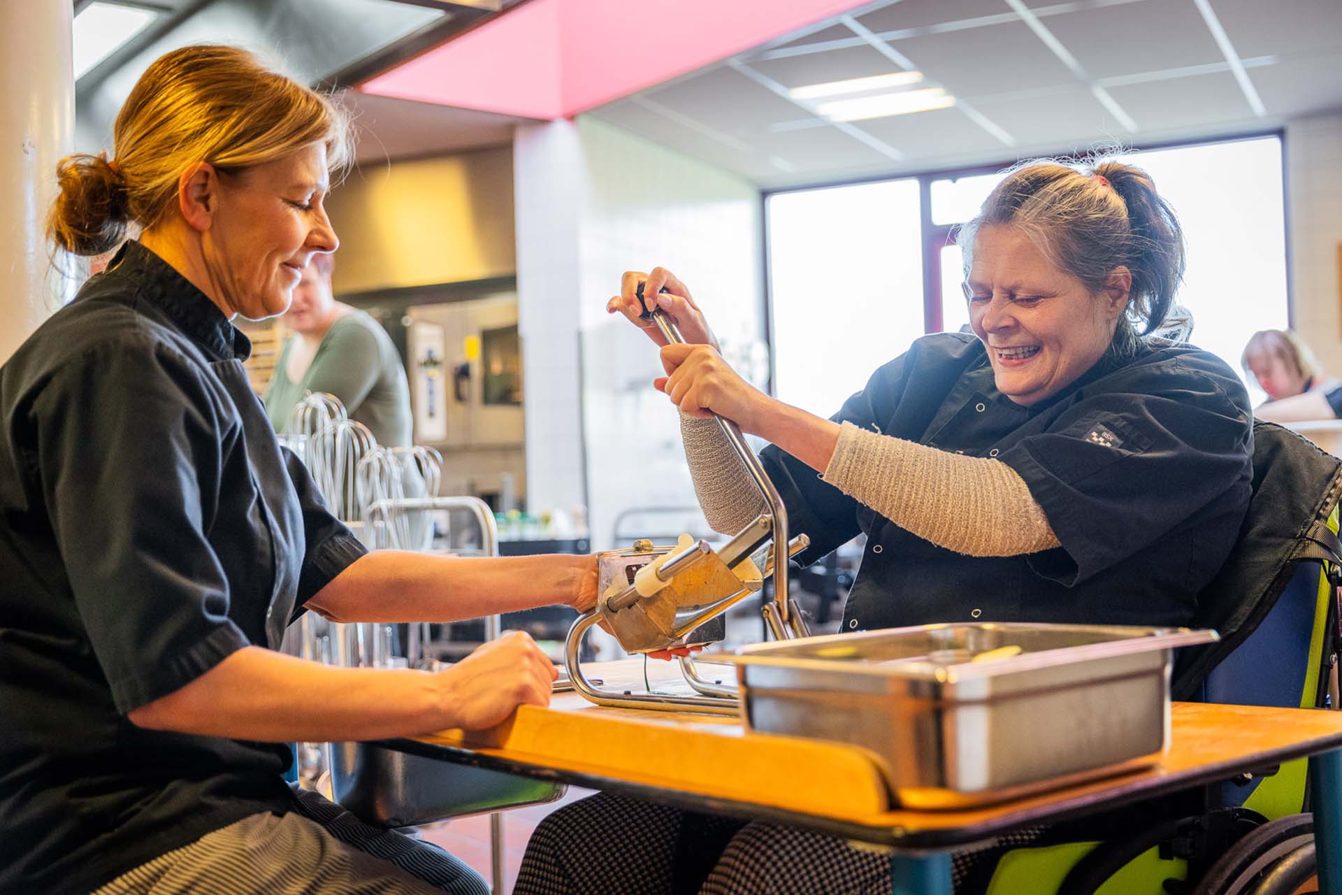 bewoner en medewerker snijden patatjes in de keuken van breidablick