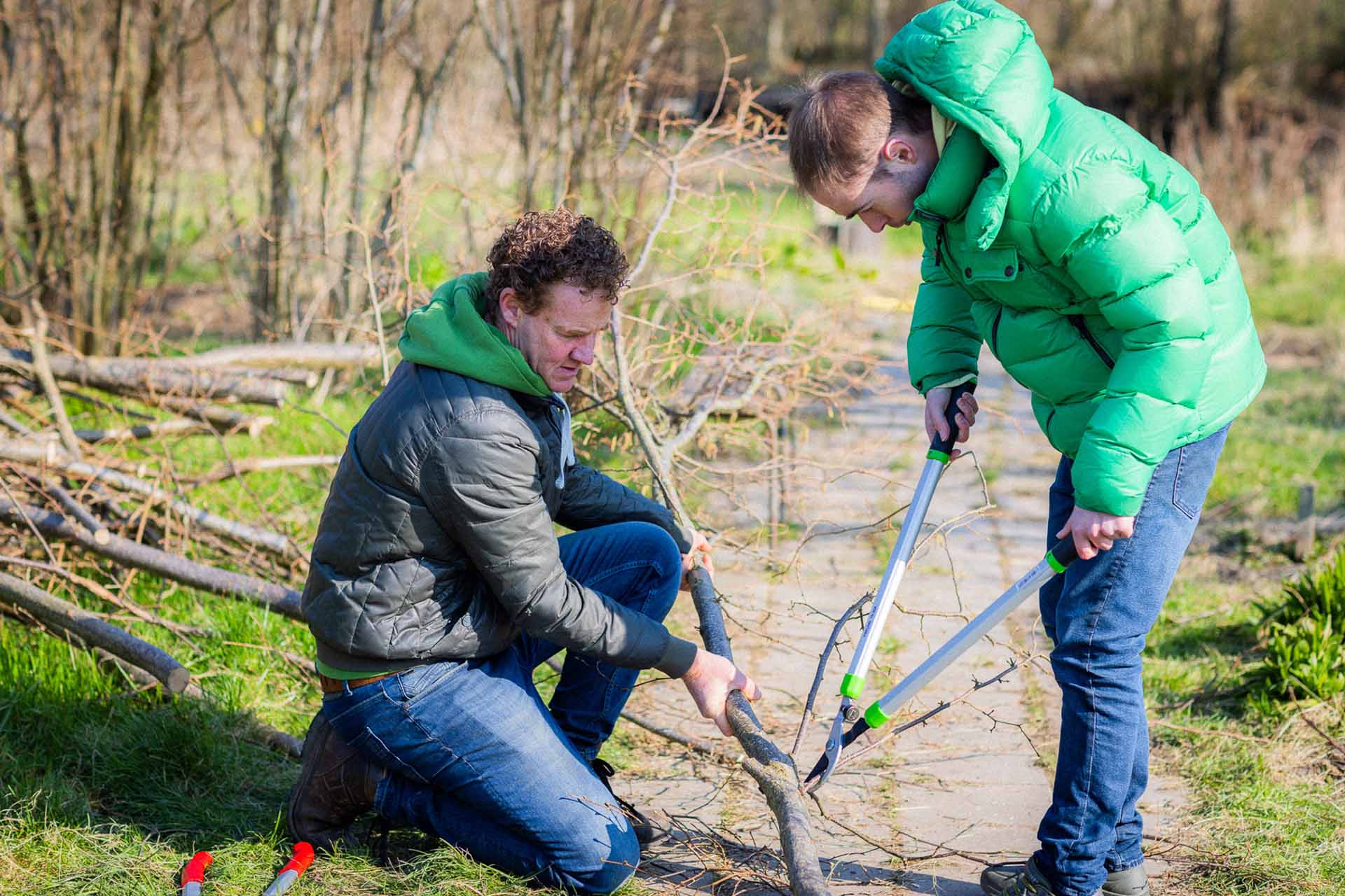 bewoner en medewerker snoeien snoeien takken op breidablick