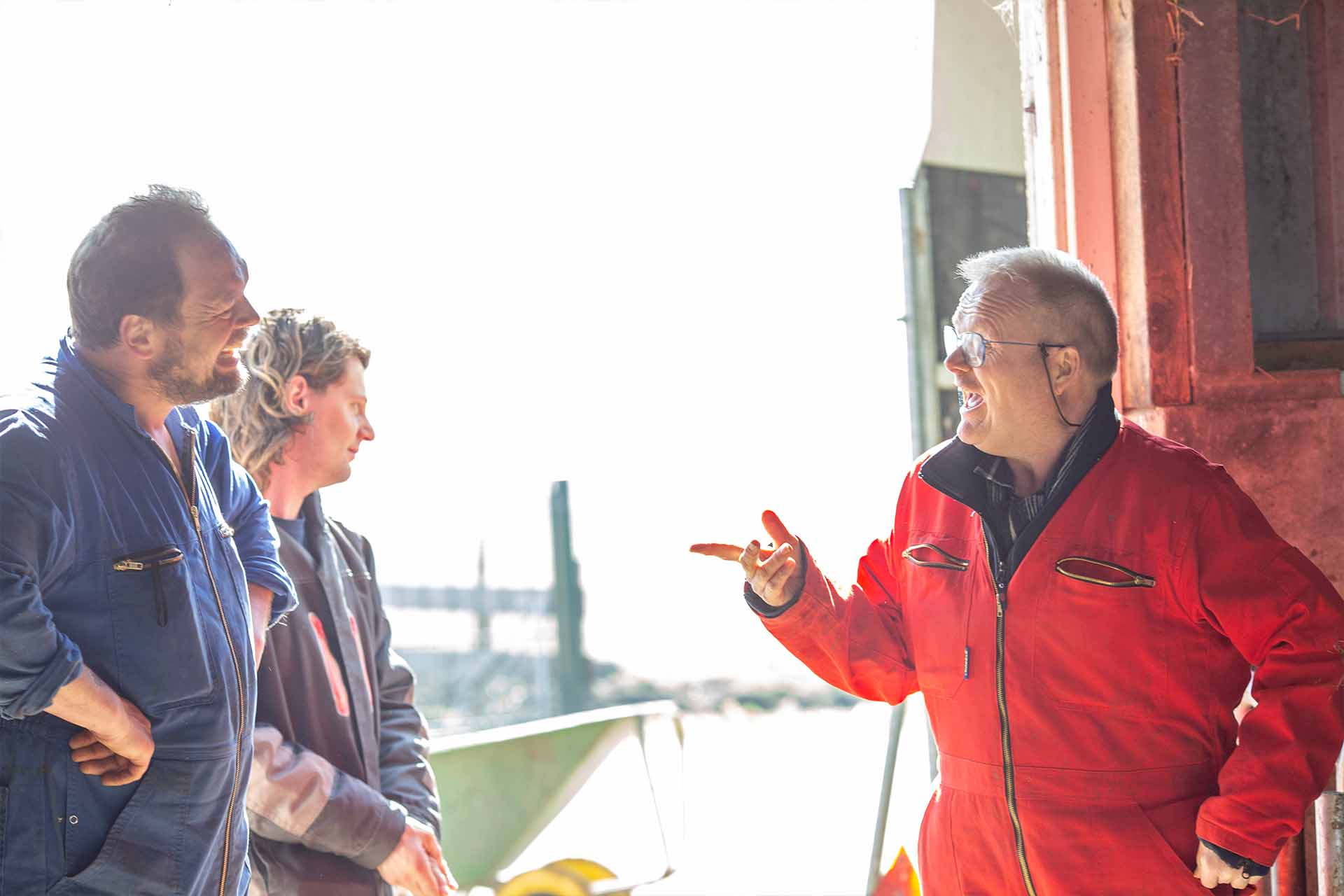 bewoners en medewerkers staan samen te lachen in de stal van artemis