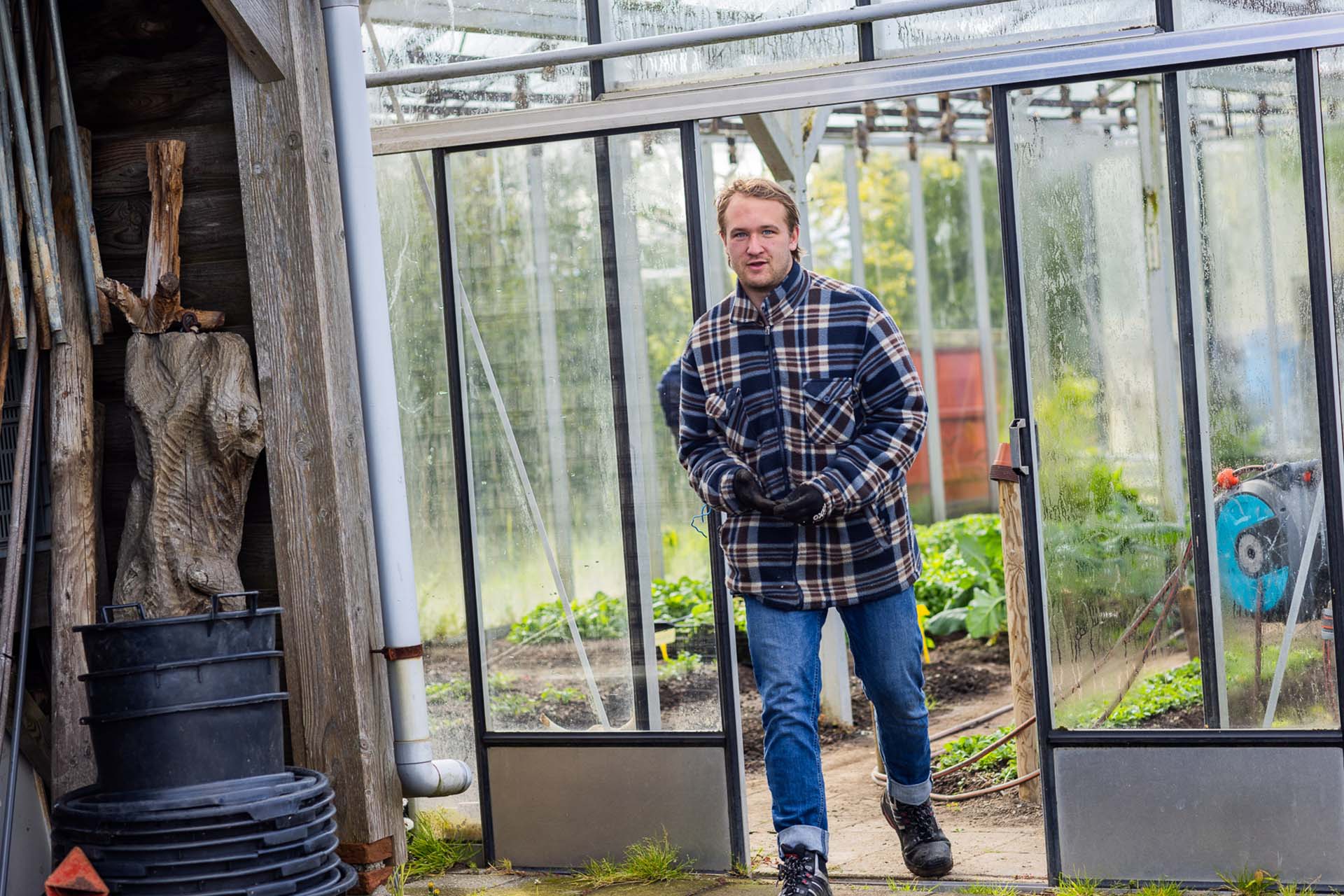bewoner in e kas die zijn handschoenen uittrekt op dijkgatshoeve