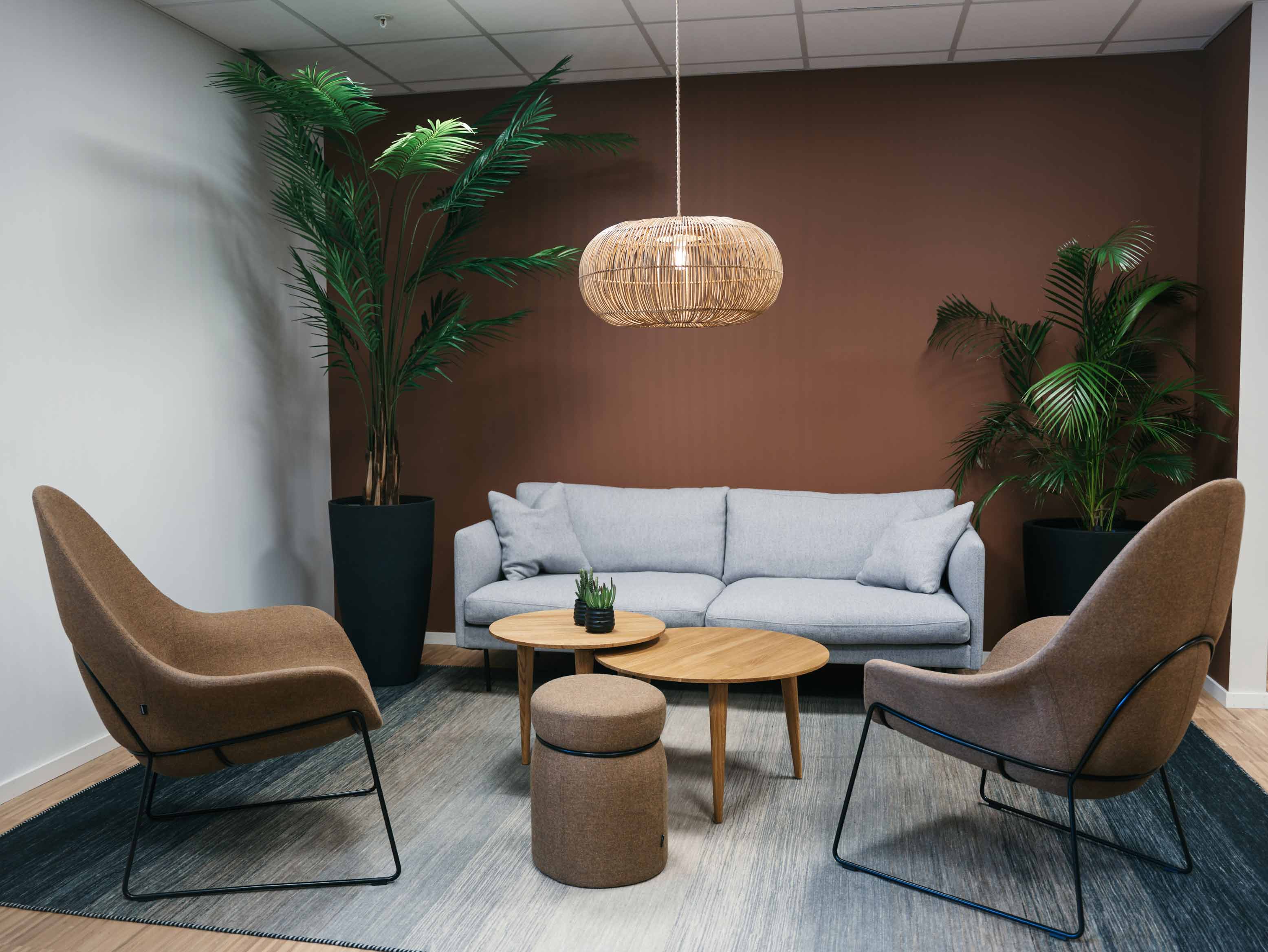 Lounge med grå sofa, to lenestoler og sofabord