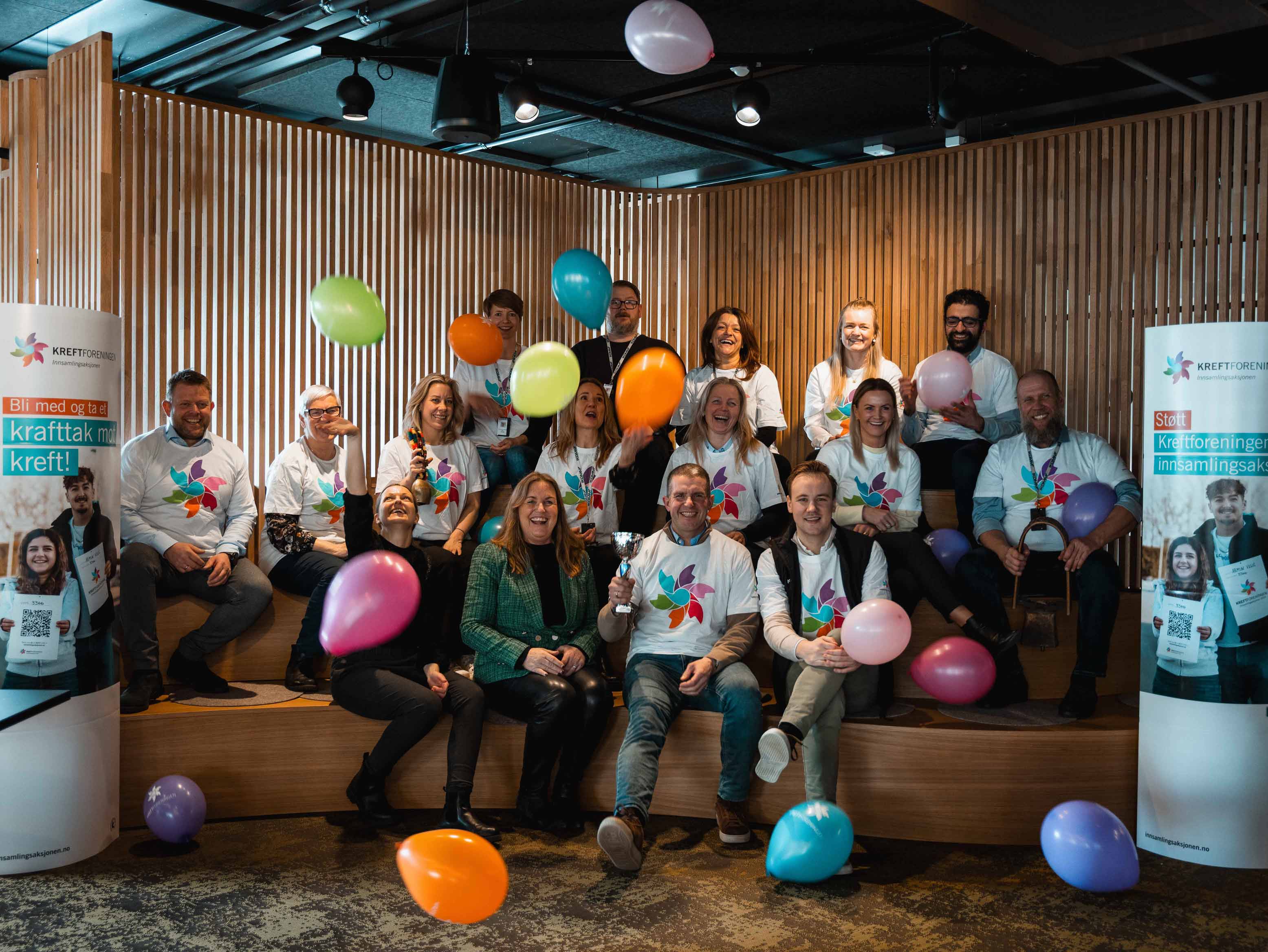 Glad gjeng i Kreftforeningen-t-skjorter feirer med ballonger
