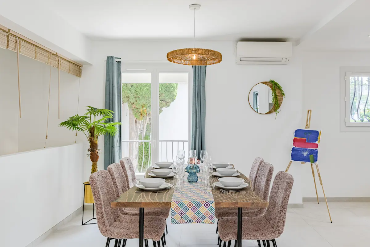 Salle à manger lumineuse d’un logement Airbnb meublé par Mobimmo, avec table en bois, chaises modernes et décoration inspirée par l’art pour créer une ambiance élégante et différenciante.