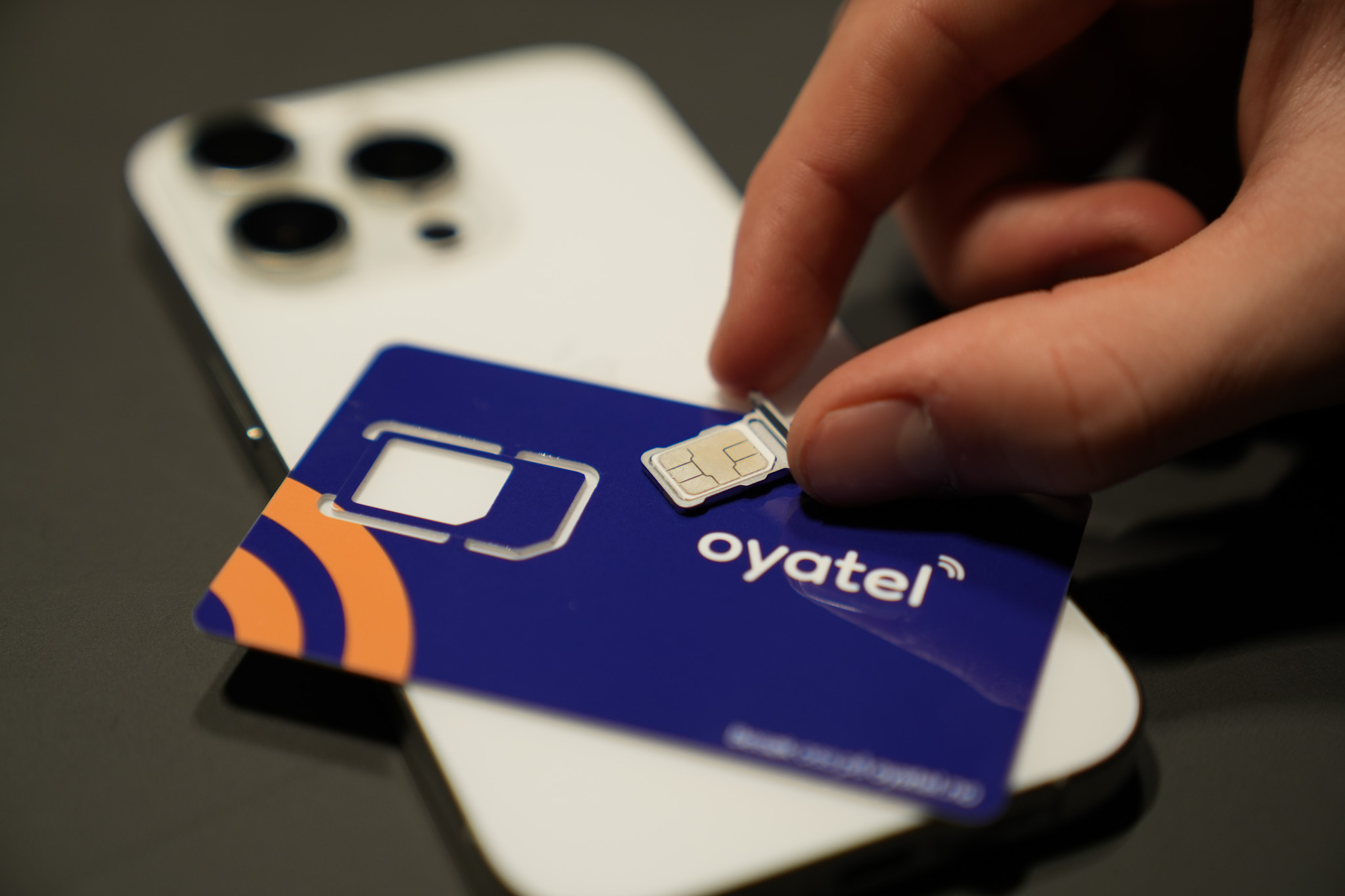 Mobiltelefon og SIM-kort som viser Oyatel-logo.