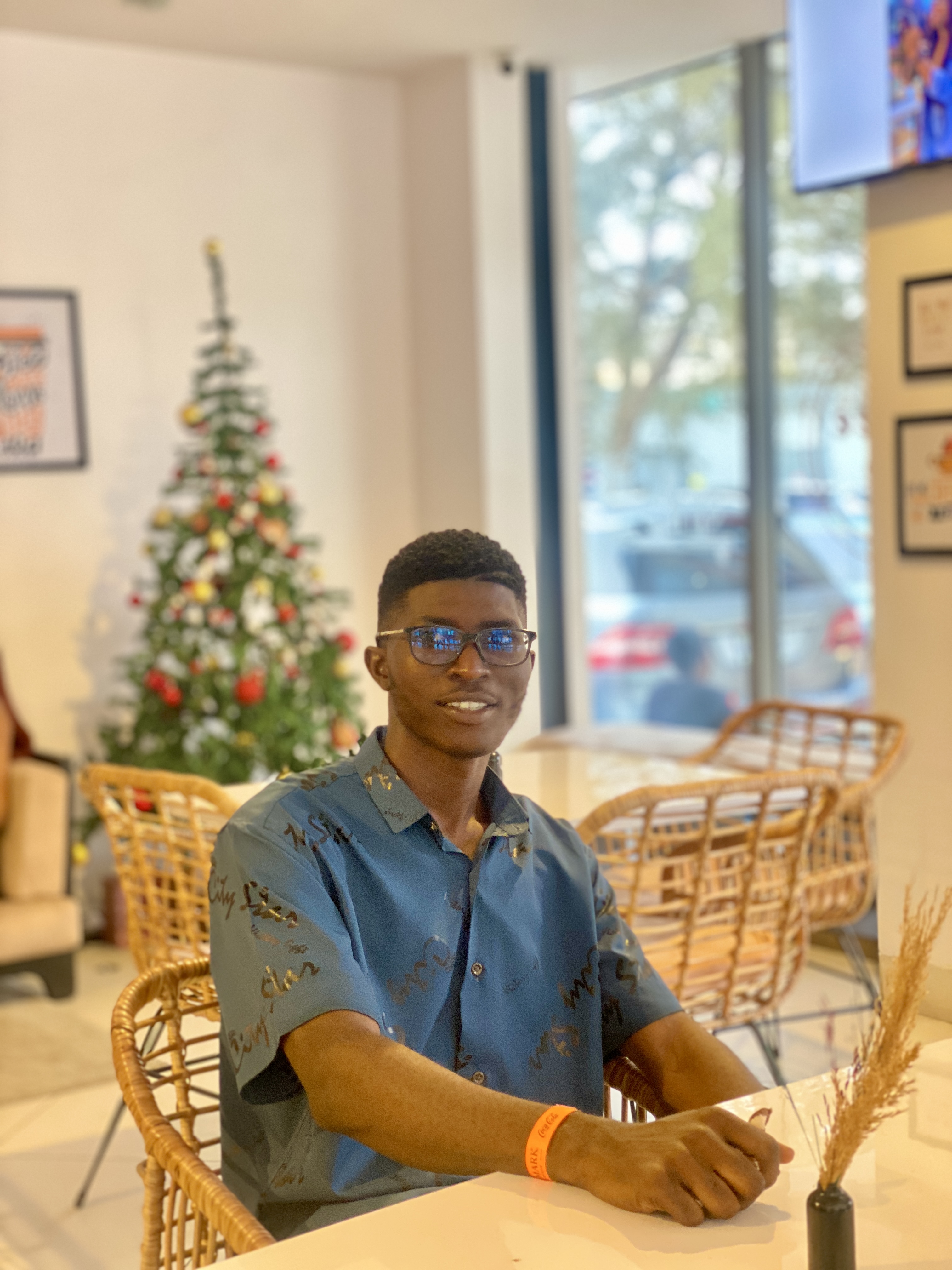 A photo of Joseph Potential sitting on a chair and carrying a laptop
