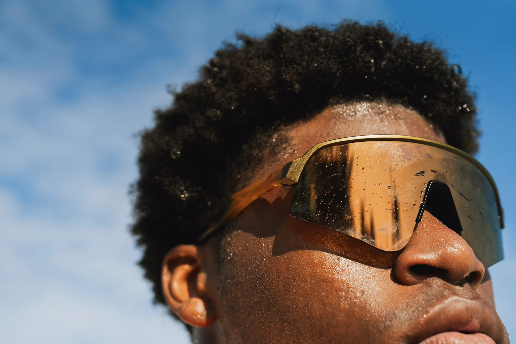 Close-up of a person wearing dark sunglasses, reflecting modern style and innovative design aesthetics.