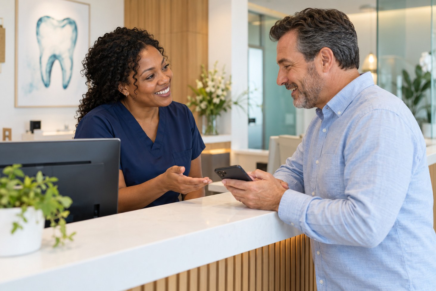 A dental office team member helping a patient with payment