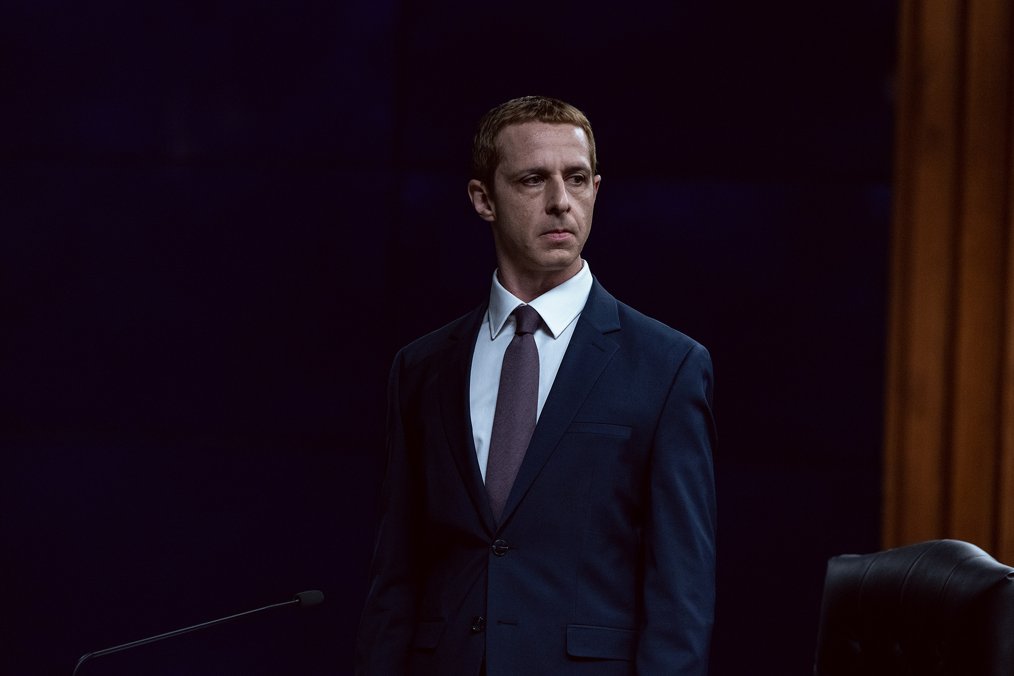 Jeremy Strong as Mark Zuckerberg standing in a hearing room in The Social Reckoning.