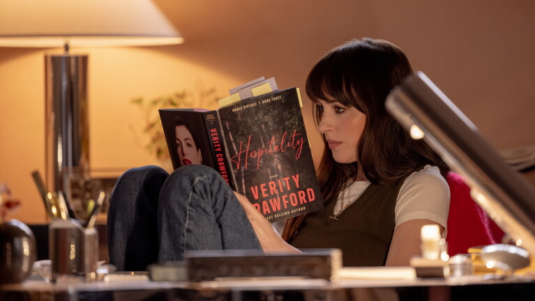 Dakota Johnson as Lowen Ashleigh reading a Verity Crawford book in Verity.