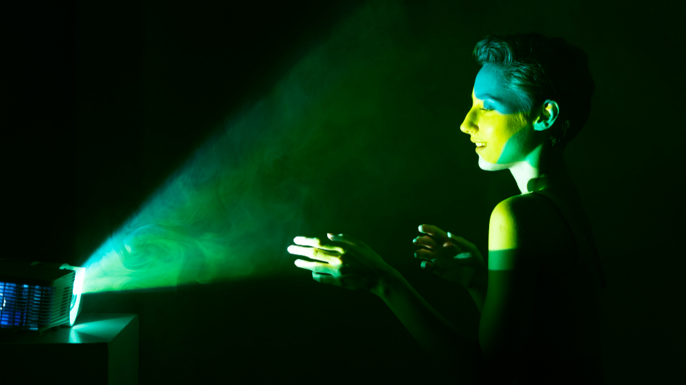 A filmmaker working in green theatrical lighting