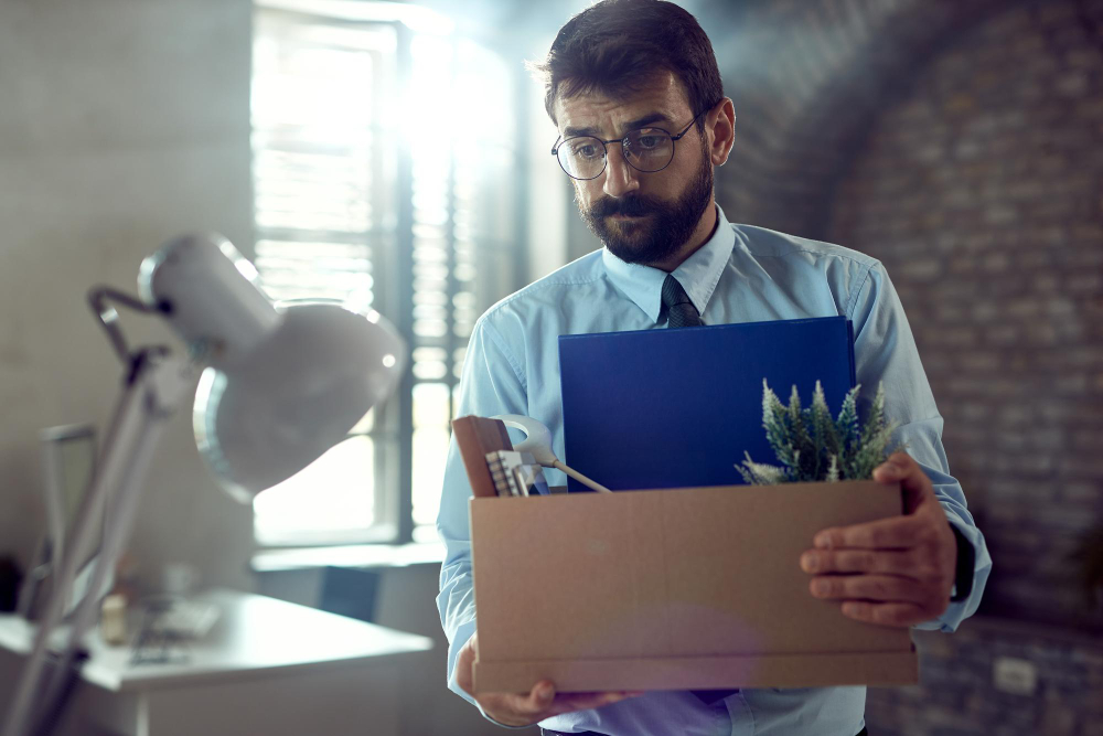 A worker carrying a box of office belongings