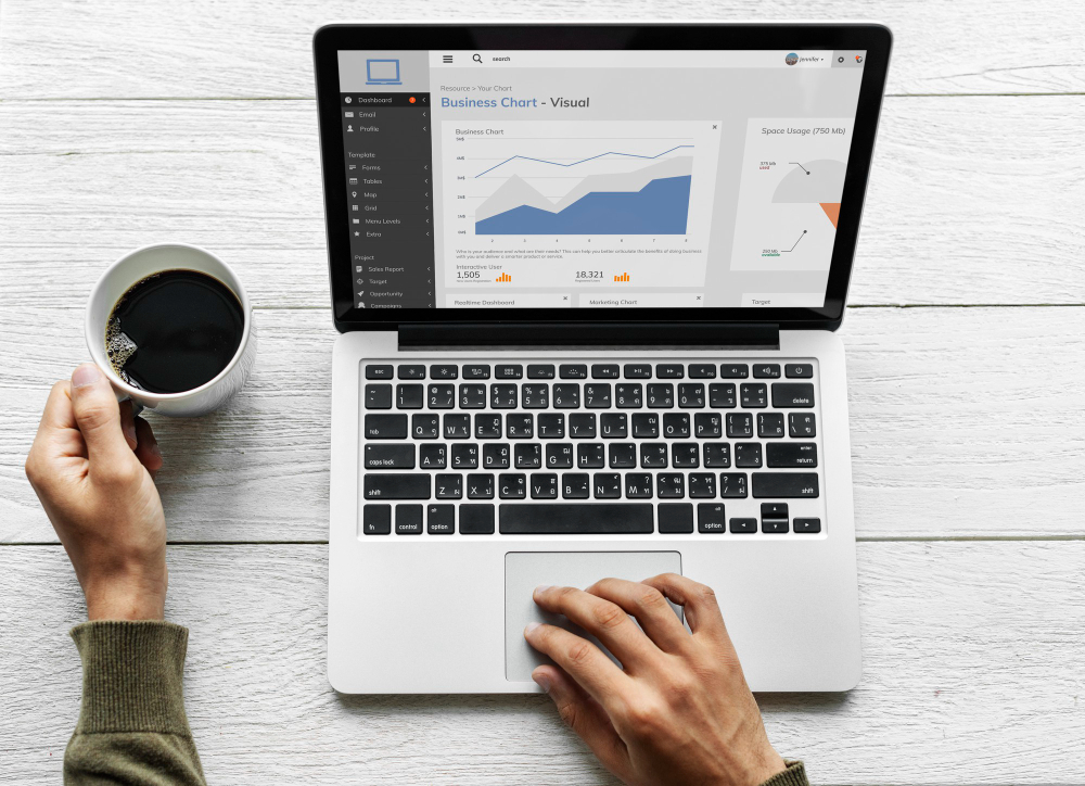 Laptop showing an analytics chart beside a coffee cup