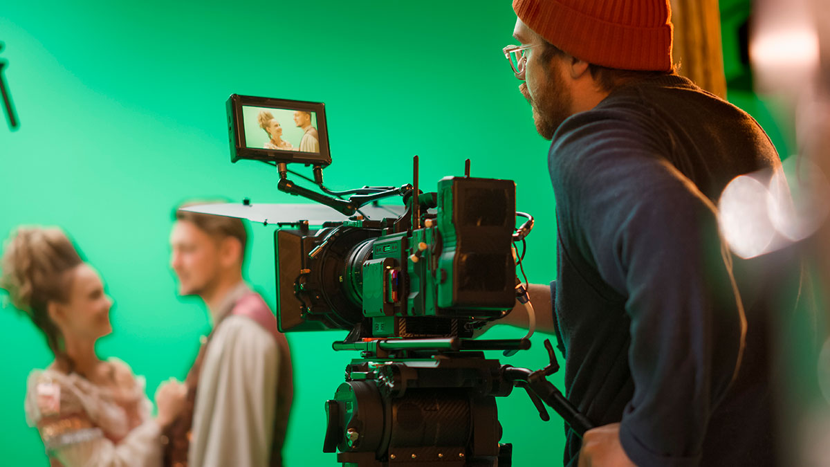 Film crew recording a scene against a green screen