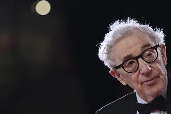 Woody Allen wearing glasses and formal clothing