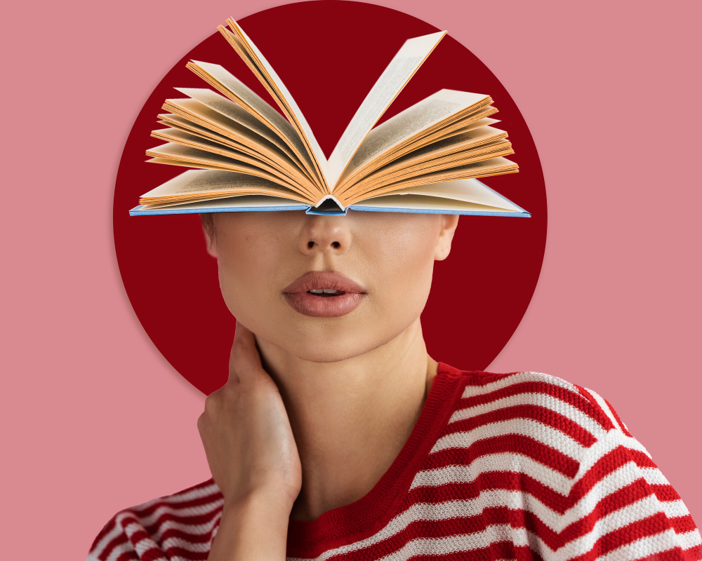 A person holding an open book above their face
