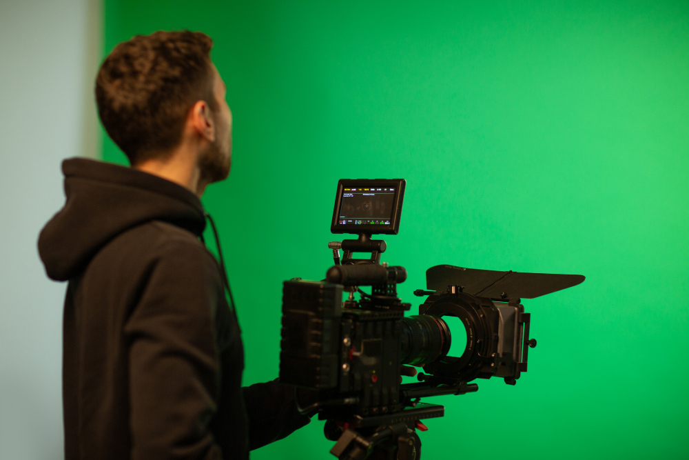 Filmmaker operating a camera against a green screen