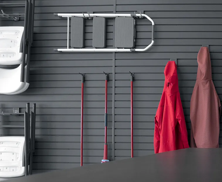 grey garage slatwall with items hanging from it. 