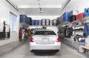 Car parked in garage with overhead shelving. 