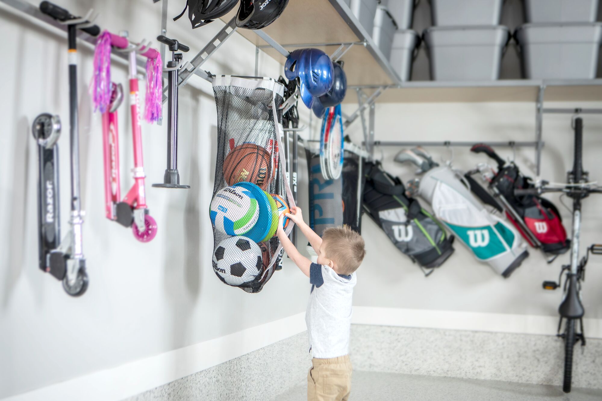 Child getting a ball out of a sports bag. 