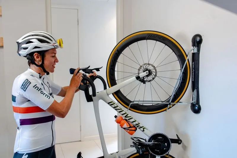 Woman putting bike on her wall mounted bike storage in Sarasota, FL