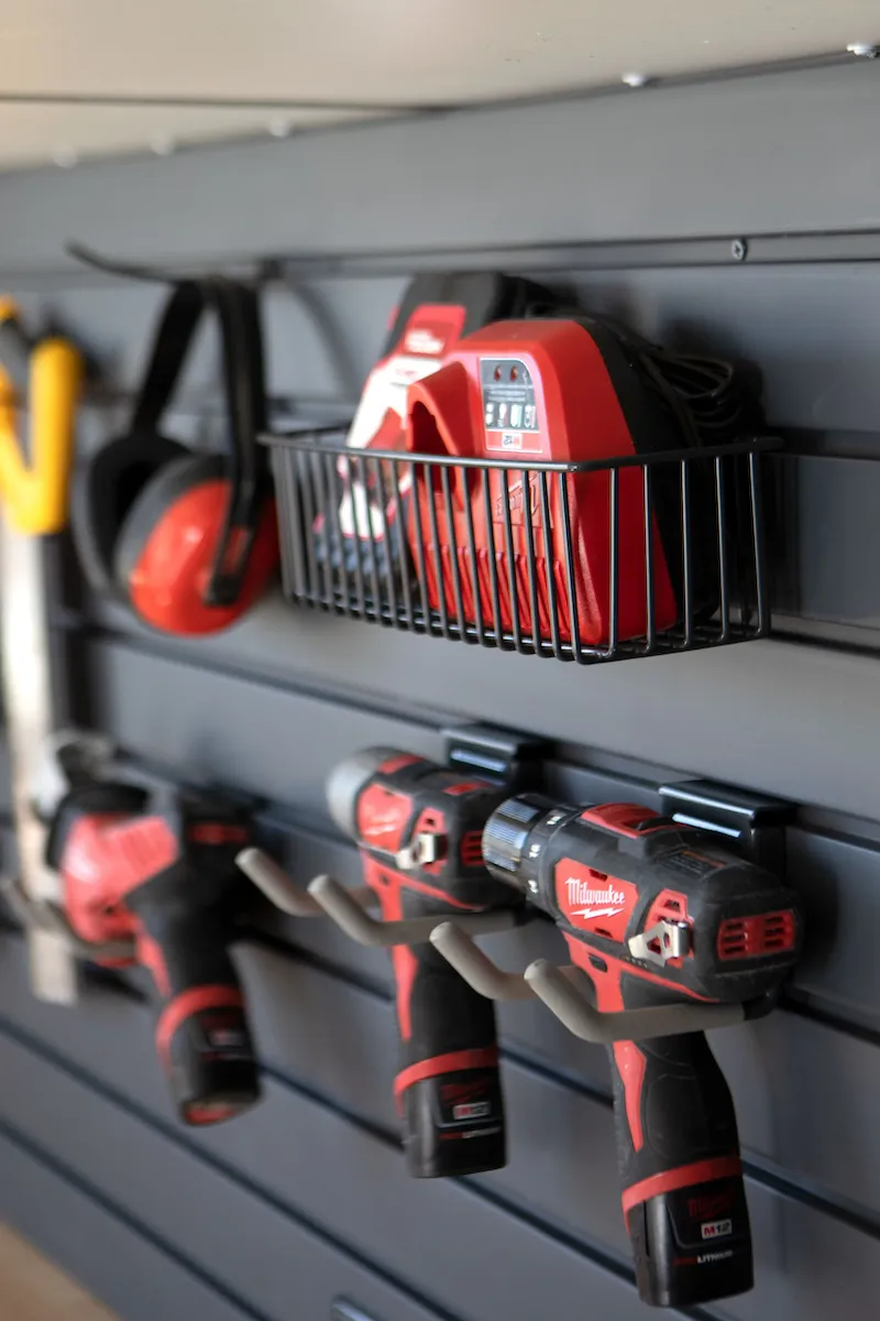 power tools hanging from grey slatwall. 