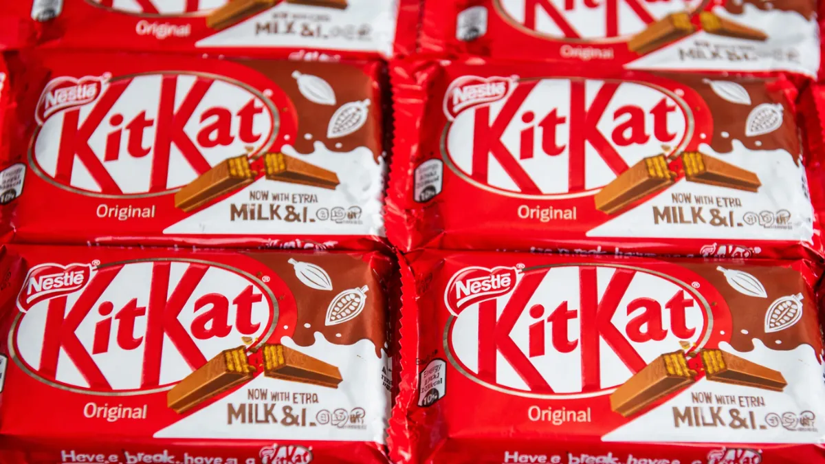 Close-up of multiple KitKat bars in their bright red packaging, neatly arranged in a grid