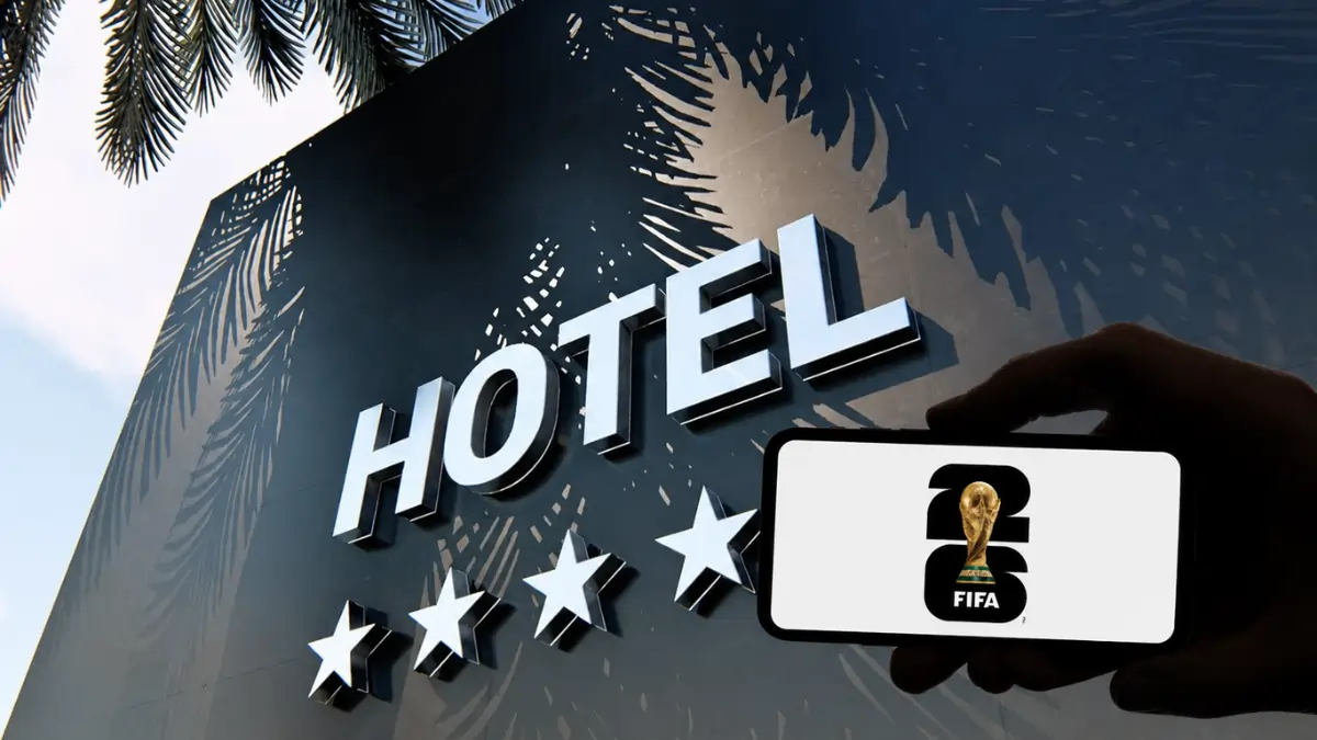 Hand holding a FIFA 2026 phone display in front of a luxury hotel