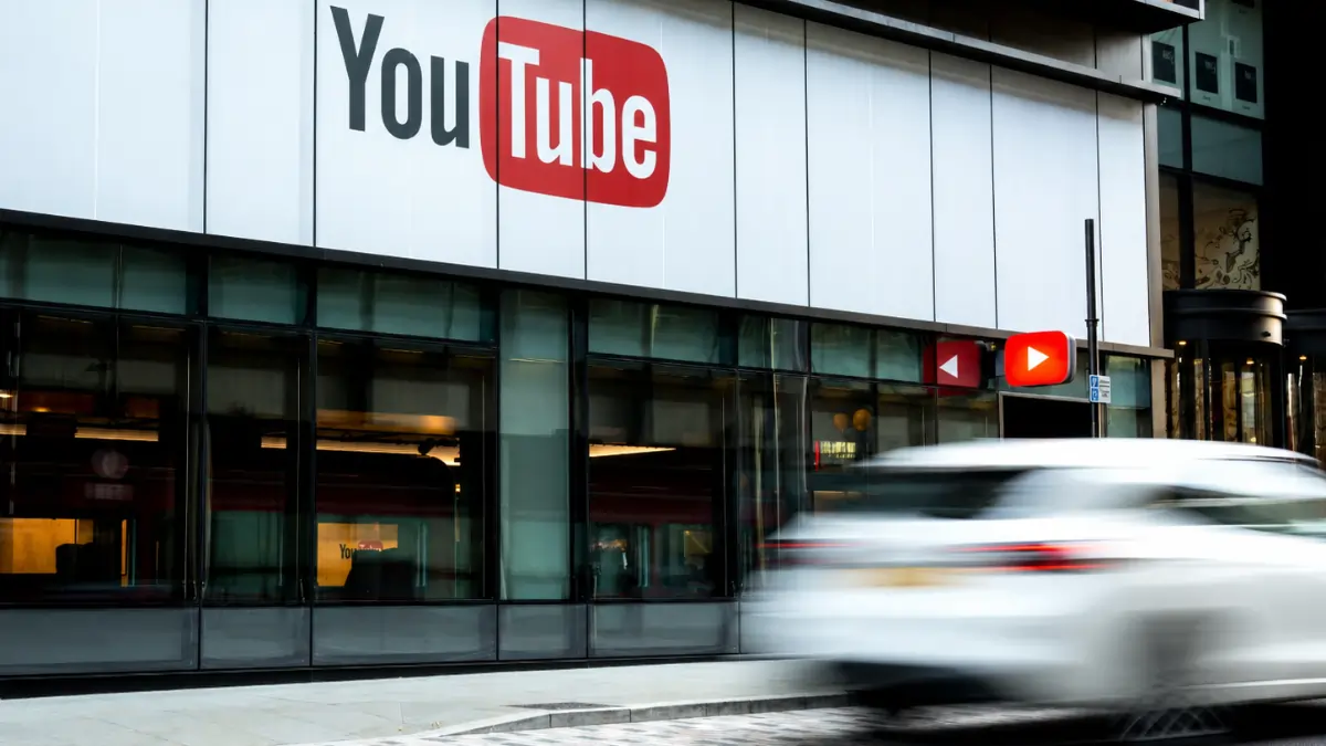 YouTube building with white passing car
