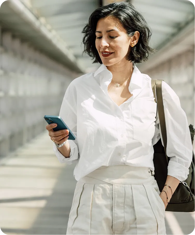 a woman in white shirt and white skirt holding a phone
