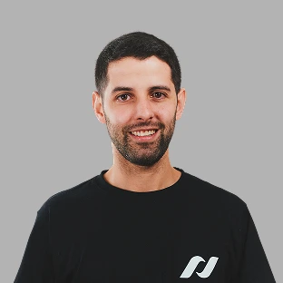Retrato profesional de un colaborador de Neocoast con remera negra y sonrisa amigable, sobre fondo gris.