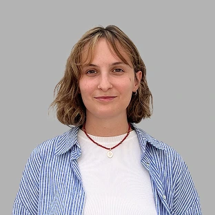 Retrato profesional de una integrante del equipo de Neocoast, posando frente a un fondo gris neutro.