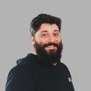 Retrato profesional de un integrante del equipo de Neocoast con barba y buzo oscuro.