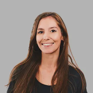 Colaboradora de Neocoast con cabello largo y suelto, sonriendo con fondo gris claro.