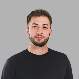 Colaborador de Neocoast con buzo negro y barba corta, posando con fondo gris claro.