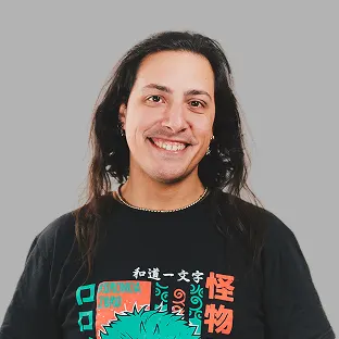 Miembro del equipo de Neocoast con remera gráfica de anime y cabello largo, posando sonriente.