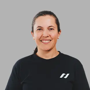 Trabajadora de Neocoast con buzo negro institucional, sonriendo al frente.